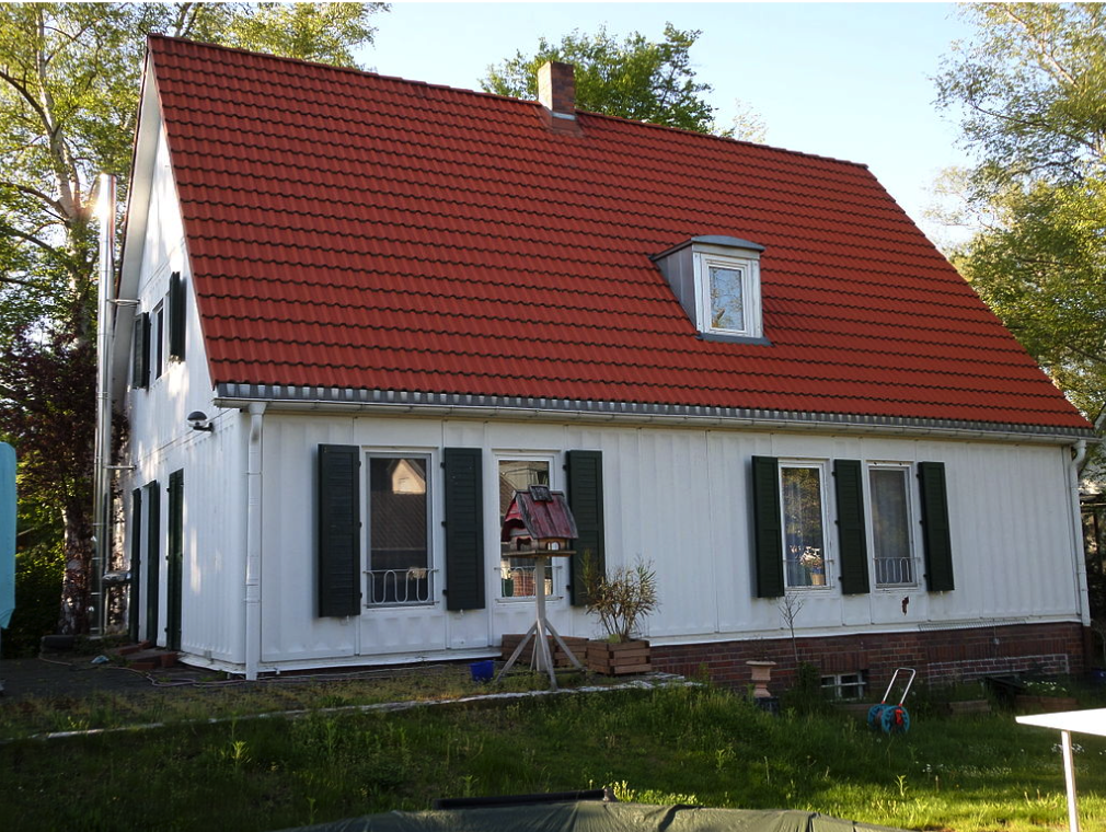 white house with a red roof and a green yard